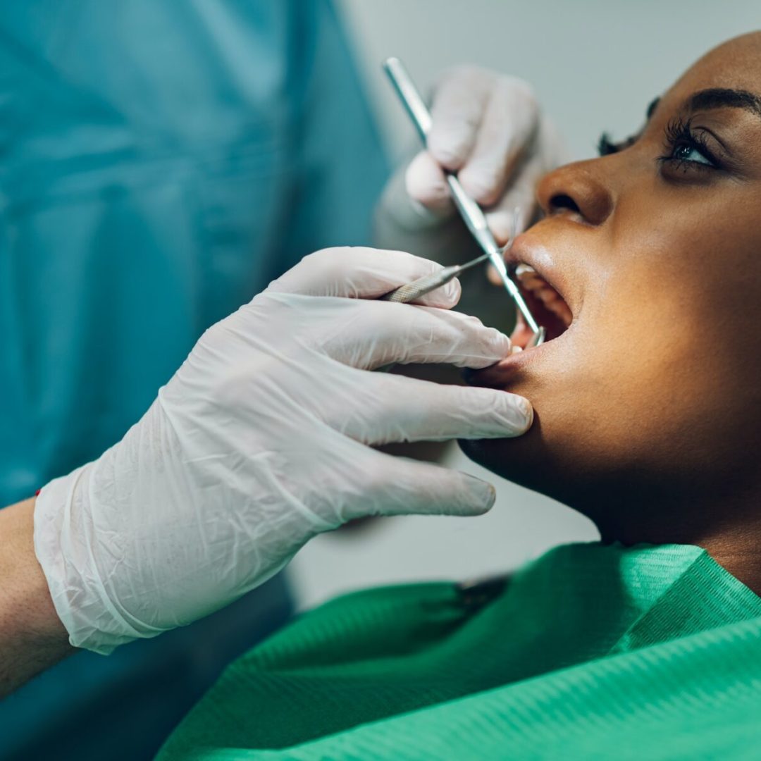 TANDLÆGE, Dentist providing dental care treatment to a african american female patient